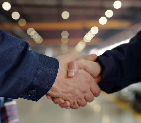 Handshake between factory executives